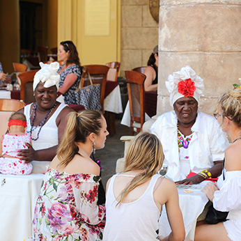 Santeria women with tourists in Old Havana plaza